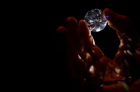 REFILE - CORRECTING YEAR An assistant holds a 102.34 carat white diamond at Sotheby's auction house in London, Britain February 8, 2018. REUTERS/Hannah McKay