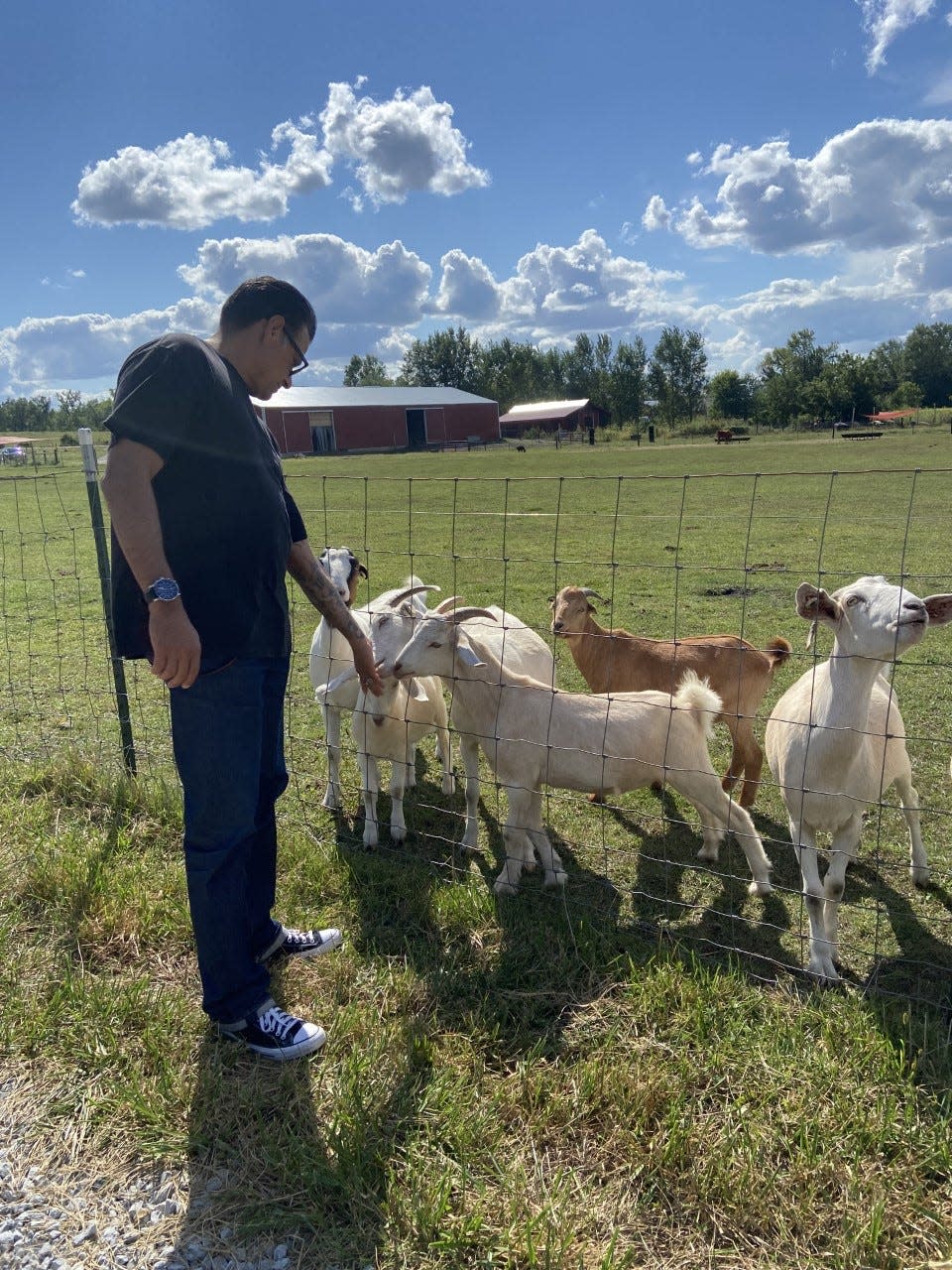 Frank Barraza stands near several goats at the Iowa Farm Sanctuary in Oxford, Sept. 11.