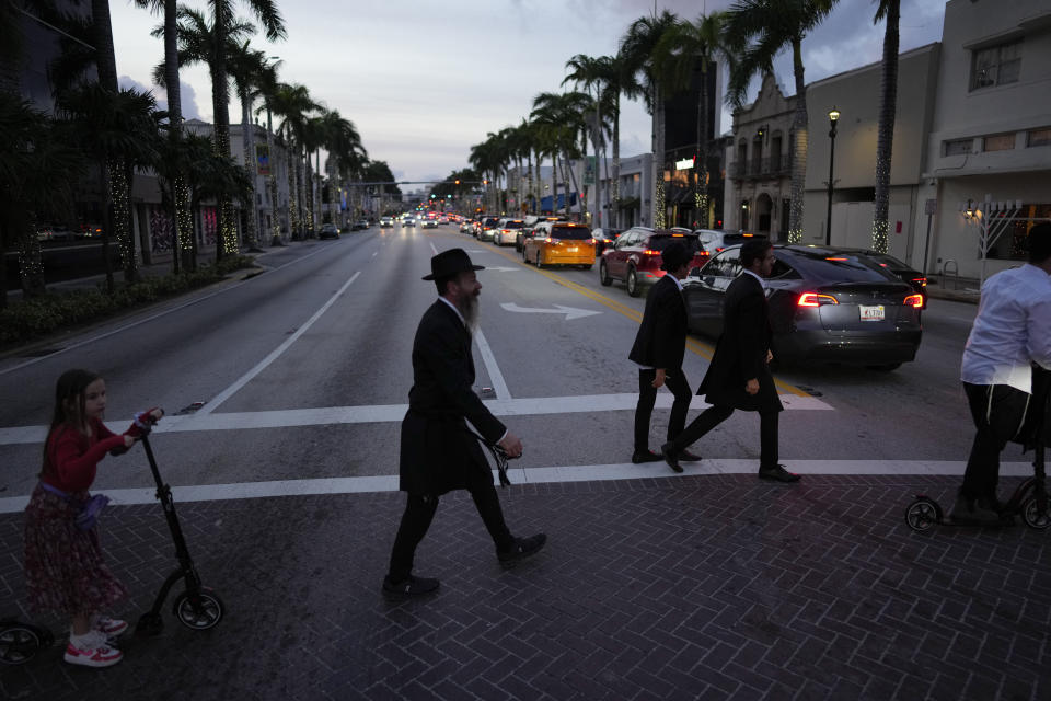 Jewish men and boys walk to synagogue for Shabbat service, in Miami Beach, Fla., Friday, Dec. 1, 2023. Daily life for many Jews has been upended by the surprise attack on Oct. 7 in Israel, when Hamas militants killed about 1,200, mostly civilians, and by the rise in antisemitism worldwide during the ensuing war, in which more than 15,800 Palestinians have died. (AP Photo/Rebecca Blackwell)