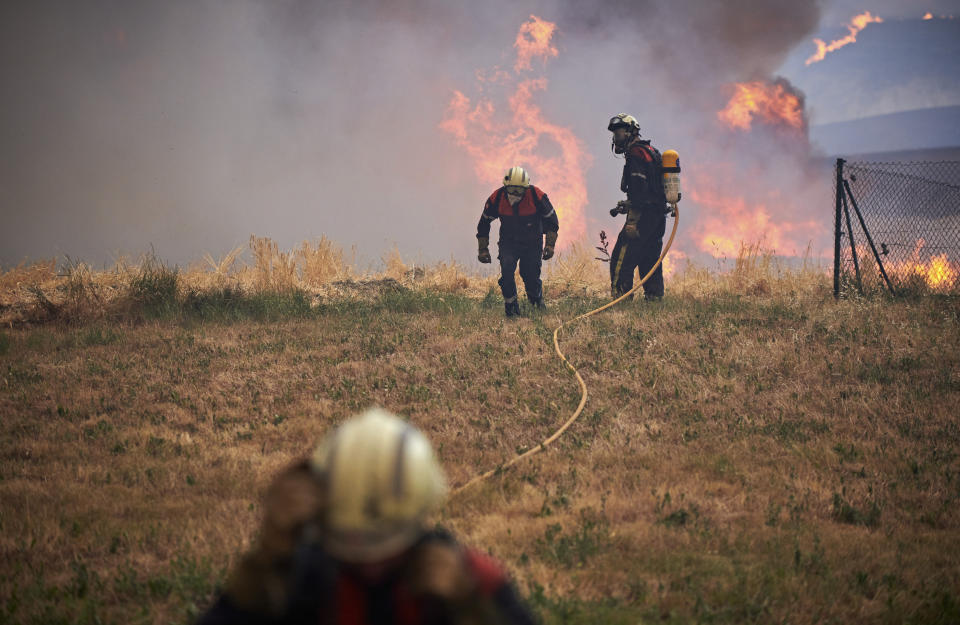 Firefighters work during a wildfire in Arraiza, northern Spain, Saturday, June 18, 2022. Firefighters in Spain are struggling to contain wildfires in several parts of the country suffering an unusual heat wave for this time of the year. (AP Photo/Sergio Martin)