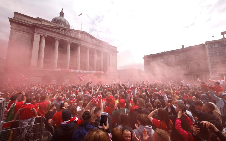 Nottingham Forest fans celebrate as the players lift the trophy during the celebrations in Old Market Square, Nottingham. Nottingham Forest won promotion to the Premier League - PA