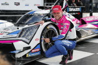 Tom Blomqvist, of New Zealand, kneels next to his Acura ARX-06 GDP after winning the pole position for the Rolex 24 hour auto race at Daytona International Speedway, Sunday, Jan. 22, 2023, in Daytona Beach, Fla. (AP Photo/David Graham)