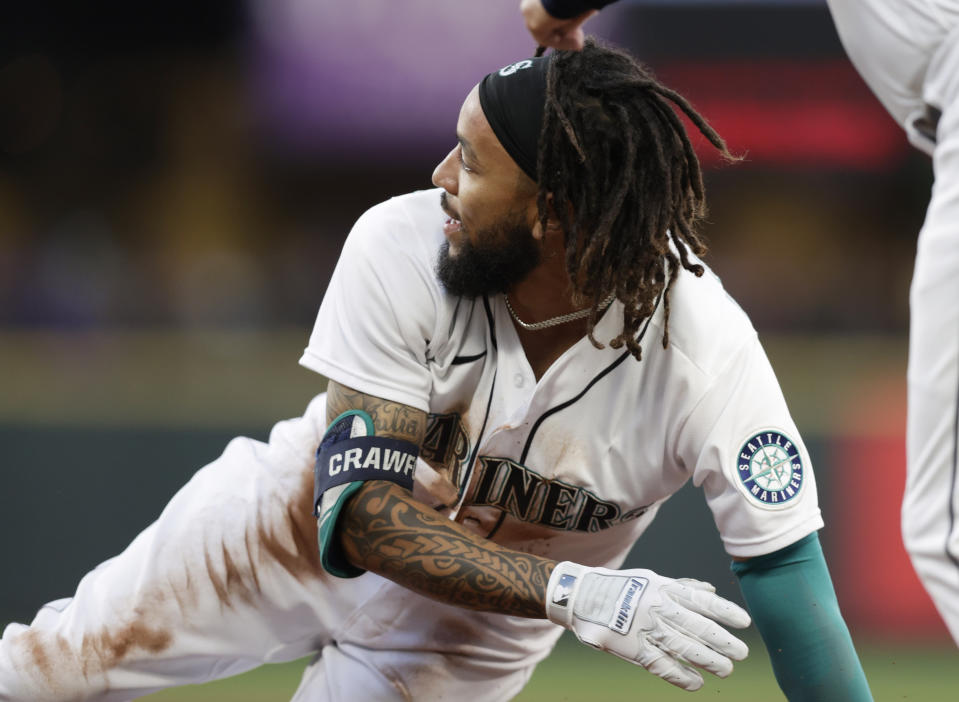 Seattle Mariners' J.P. Crawford looks back to home from the ground on first after hitting an RBI single against the Colorado Rockies during the fifth inning of a baseball game, Tuesday, June 22, 2021, in Seattle. (AP Photo/John Froschauer)