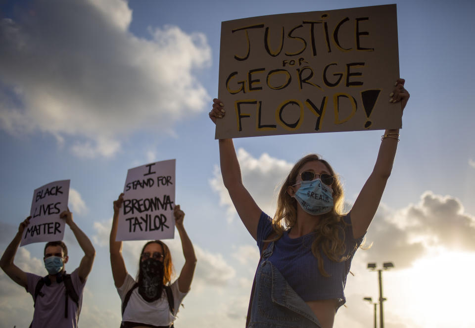 FILE - In this Tuesday, June 2, 2020 file photo protesters hold signs and shout slogans during a protest to decry the killing of George Floyd in front of the U.S. Embassy Branch Office, in Tel Aviv, Israel. (AP Photo/Ariel Schalit, File)