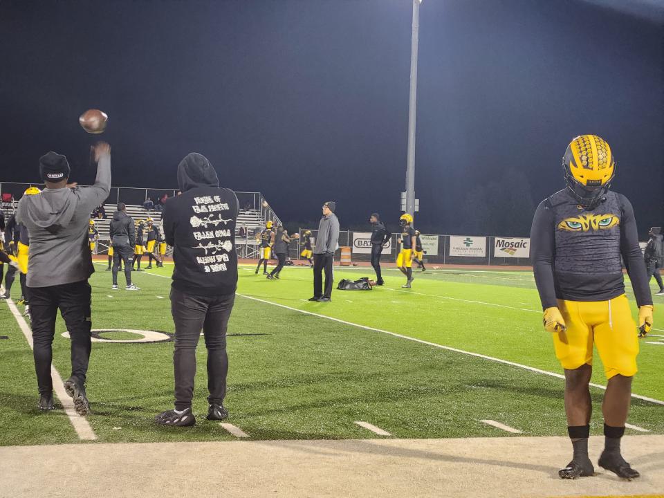 St. James players and coaches warm up prior to Friday's LHSAA high school football quarterfinal game against Many.