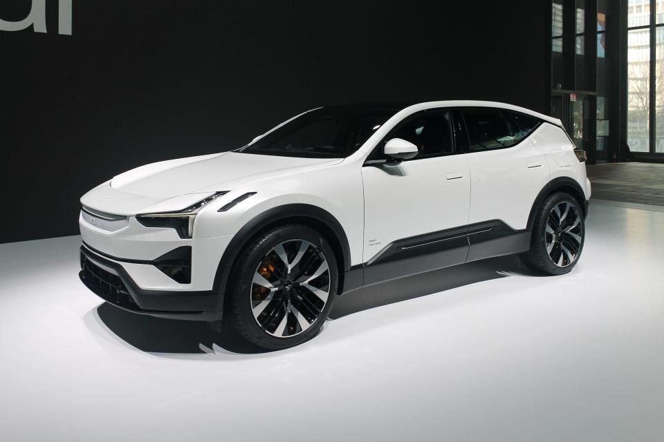 A white Polestar 3 electric SUV, viewed from the front, against a black and white background.