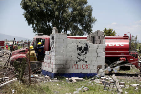 Firefighters inspect a tanker truck at a site damaged due to fireworks explosions in the municipality of Tultepec, on the outskirts of Mexico City, Mexico July 5, 2018. REUTERS/Daniel Becerril