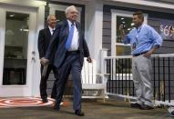 Berkshire Hathaway CEO Warren Buffett (C) prepares to throw a newspaper off the porch of a Clayton Home house with Kevin T. Clayton (L), CEO of Berkshire subsidiary Clayton Homes prior to the Berkshire annual meeting in Omaha, Nebraska May 2, 2015. REUTERS/Rick Wilking