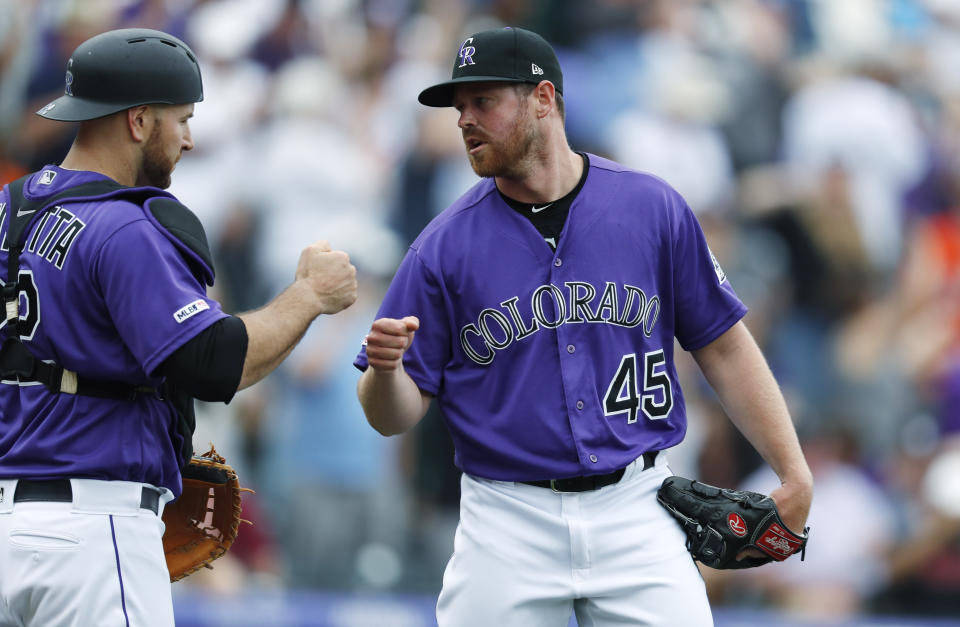 Colorado Rockies catcher Chris Iannetta, left, congratulates relief pitcher Scott Oberg who retired San Francisco Giants pinch hitter Pablo Sandoval for the final out in the ninth inning of a baseball game Sunday, Aug. 4, 2019, in Denver. (AP Photo/David Zalubowski)