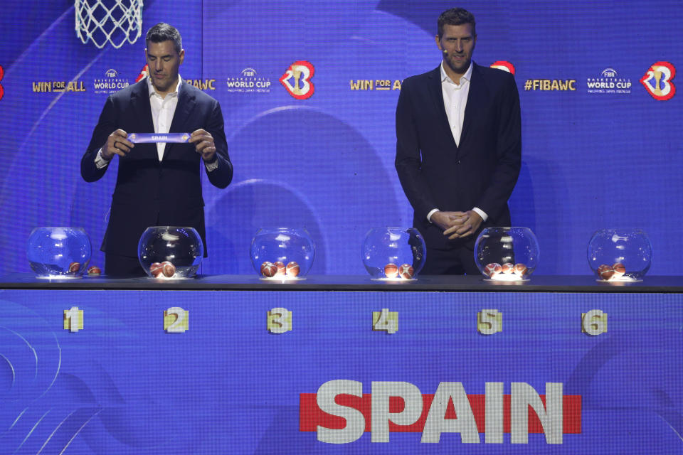 FIBA ambassador and former NBA star Luis Scola, left, shows the ticket for Spain national basketball team beside German former basketball player and NBA star Dirk Nowitzki during the FIBA World Cup 2023 draw in Quezon city, Philippines on Saturday April 29, 2023. (AP Photo/Josefino de Guzman)