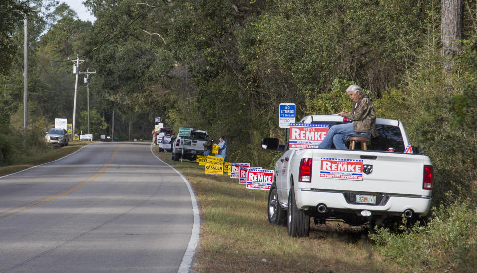 Candidate supporters solicit last minute votes on the side of the road leading to the rural County Polling House in Crawfordville, Florida, on Nov. 8.&nbsp;