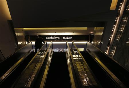 A man rides an escalator on his way to Sotheby's Beijing Art Week in Beijing, November 28, 2013. Sotheby's will hold its first major auction on the Chinese mainland on Sunday as competition between the New York-based auction house and its long-time rival Christie's moves into one of the world's hottest art markets amid a government crackdown on corruption and luxury spending. REUTERS/Kim Kyung-Hoon