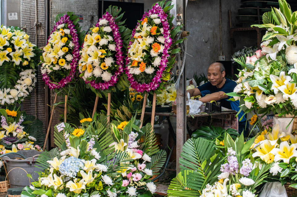 HONG KONG, CHINA - 2022/03/18: A florist prepares flowers for memorial services as Hong Kong deals with the latest COVID-19 outbreak. Hong Kong has recorded over one million cases of COVID-19 and more than 5400 deaths, the vast majority occurring within the past several weeks. Funeral parlours and associated services are working overtime to meet demand. (Photo by Ben Marans/SOPA Images/LightRocket via Getty Images)