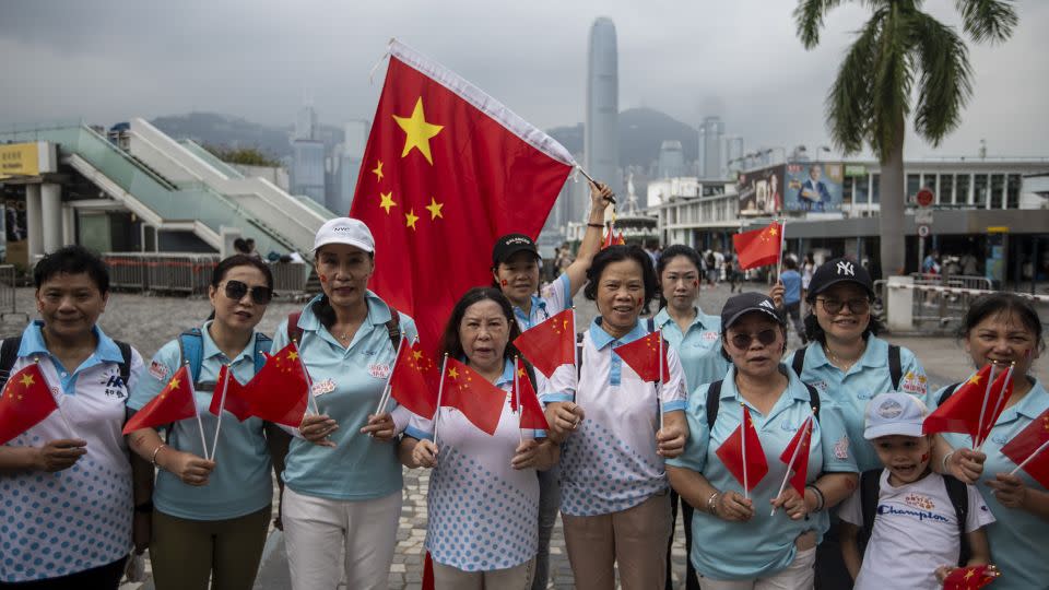 People wave Chinese flags to mark China's National Day in Hong Kong on October 1, 2023. - Vernon Yuen/NurPhoto/Getty Images