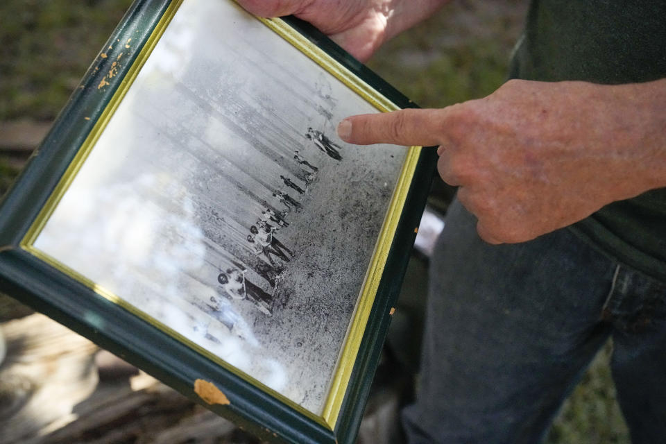 Jesse Wimberley shows an old family photo depicting workers gathering sap for turpentine on what his now his property Wednesday, Nov. 8, 2023, in West End, N.C. Grassroots forest burners are proving key to restoring a fire-loving ecosystem across the South. (AP Photo/Chris Carlson)