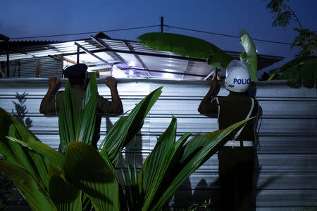 Police officers look over the tin walls of a training camp allegedly linked to Islamist militants, in Kattankudy near Batticaloa, Sri Lanka, May 5, 2019. REUTERS/Danish Siddiqui