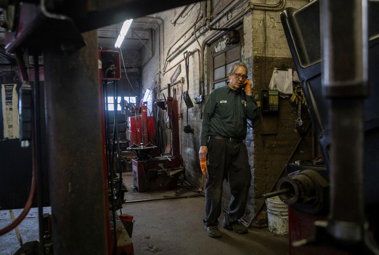 Mike Warholak Jr. answers the phone during the last day of ownership by the Warholak family inside the Warholak Tire Service garage in Detroit on Tuesday, Oct. 31, 2023.