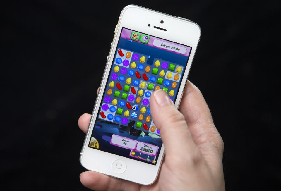 A woman poses for a photo illustration with an iPhone as she plays Candy Crush in New York February 18, 2014. King, the Swedish firm behind hit mobile phone game Candy Crush Saga, is planning a U.S. stock market debut which some analysts think could value it at more than $5 billion and herald a flurry of technology company listings this year.   REUTERS/Carlo Allegri (UNITED STATES - Tags: BUSINESS SCIENCE TECHNOLOGY)