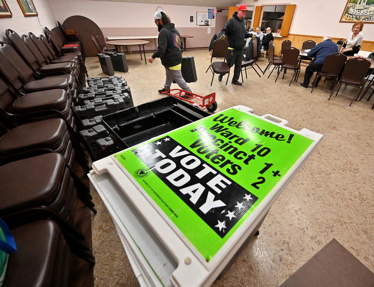 Worcester Parks Department employees Brian Rydant, right, and Rich Mayne work Monday to set up the polling station at the city's St. Spyridon Senior Center.