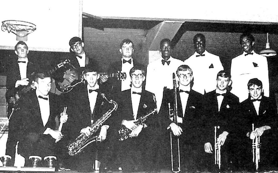 The guys that played in the original Sanction in the 1968 BoB competition were, in the famous 'basketball goal picture, front row, from left: Steve Davis, drums; Dan Crass, tenor; Doug Kwasnoski, alto; Richard Anderson, trombone; Bobby Wedemeyer, trumpet; and Jerry Ferrari, trumpet. Back row: Jake Alexander, bass; David McDuffie, guitar; Rob Culpepper, organ; Bill Capshaw, vocals; Lloyd Jones, vocals; and Aaron Love, vocals. Not pictured, band manager Charlie Johnson. Johnson, Kwasnoski, Ferrari, and Jones are now deceased. Alexander and Capshaw still live in Oak Ridge. McDuffie, Culpepper, and Anderson live in Knoxville. Crass lives in Nashville. The Honorable Robert C. Wedemeyer lives near Nashville and, since 1990, sits on the Middle Tennessee Court of Criminal Appeals. The whereabouts of Aaron Love are unknown.