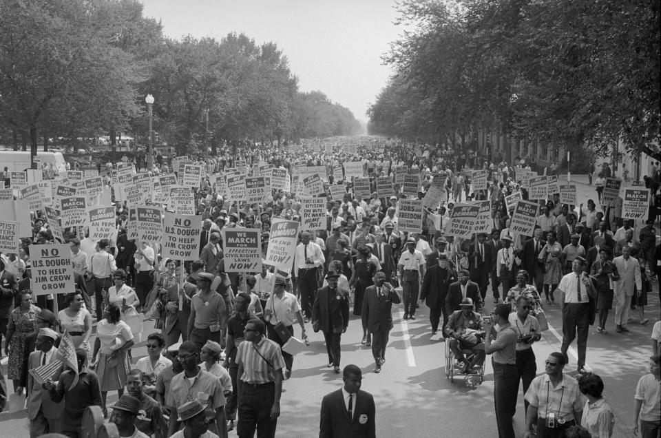 Thousands of protesters march in this black-and-white image holding signs that read: We march for effective civil rights laws now and UAW says jobs and freedom for every American, among other signs.