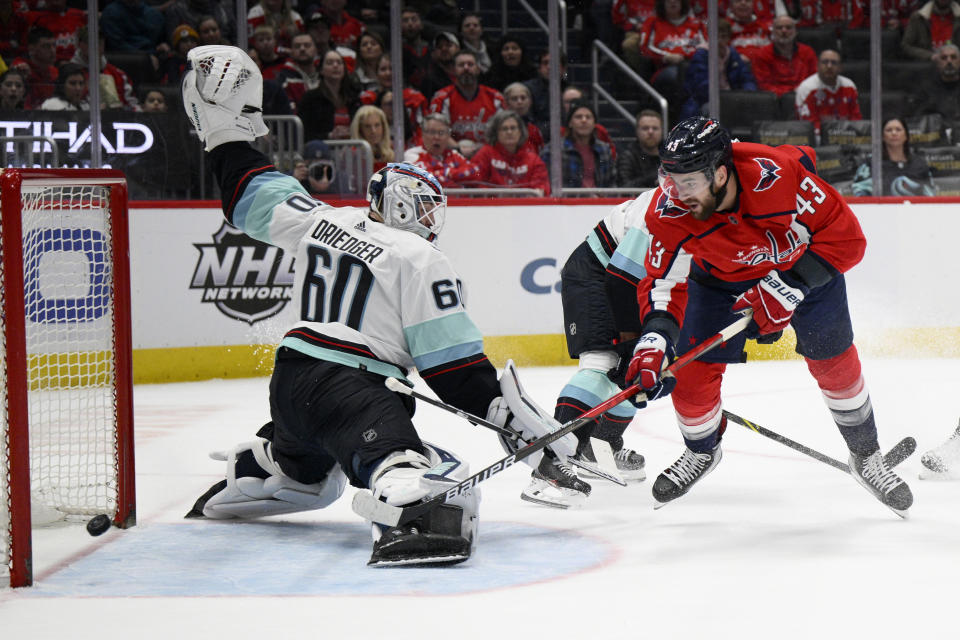 Washington Capitals right wing Tom Wilson (43) scores against Seattle Kraken goaltender Chris Driedger (60) during the first period of an NHL hockey game, Saturday, March 5, 2022, in Washington. (AP Photo/Nick Wass)