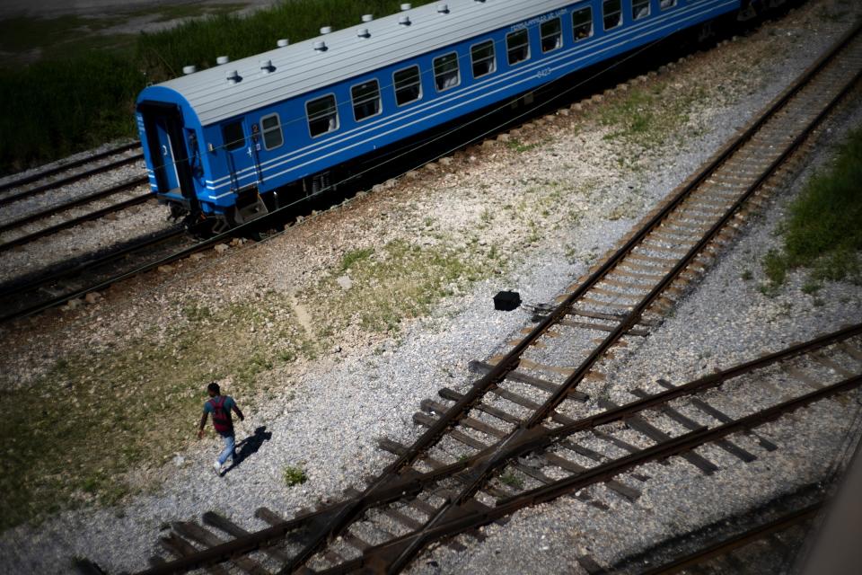 A man walks near the first train using new equipment from China rides past, in Havana, Cuba, Saturday, July 13, 2019. The first train using new equipment from China pulled out of Havana Saturday, hauling passengers on the start of a 915-kilometer (516-mile) journey to the eastern end of the island as the government tries to overhaul the country’s aging and decrepit rail system. (AP Photo/Ramon Espinosa)