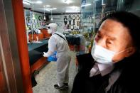 An employee from a disinfection service company sanitizes a traditional market in Seoul