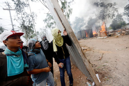 Supporters of Salvador Nasralla, presidential candidate for the Opposition Alliance Against the Dictatorship, clash with riot police as they wait for official presidential election results in Tegucigalpa, Honduras, November 30, 2017. REUTERS/Edgard Garrido