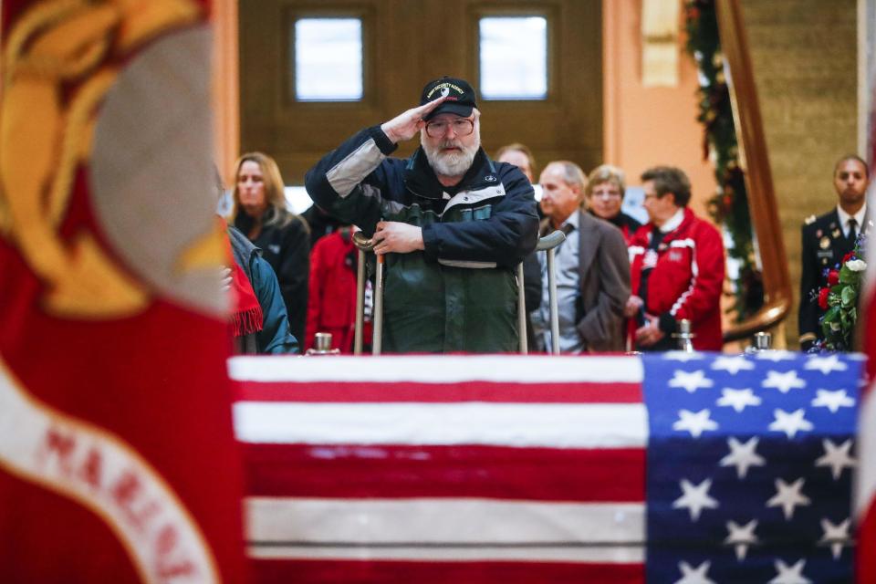 A mourner salutes the casket of John Glenn as he lies in honor, Friday, Dec. 16, 2016, in Columbus, Ohio. Glenn's home state and the nation began saying goodbye to the famed astronaut who died last week at the age of 95. (AP Photo/John Minchillo)