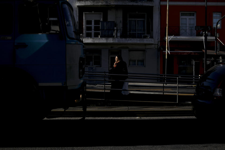 A woman waits for the bus in Buenos Aires, Argentina, Tuesday, Aug. 13, 2019. Increasing hardship has been evident for some time in Argentina. Many struggle to pay utility bills. Families living on the streets outside shopping malls, bus stations and parks have become an increasingly common sight in Buenos Aires. (AP Photo/Natacha Pisarenko)