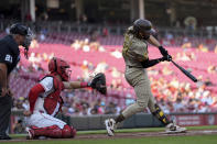 San Diego Padres' Fernando Tatis Jr. singles to left field for his 500th career hit, against the Cincinnati Reds during the first inning of a baseball game Tuesday, May 21, 2024, in Cincinnati. Reds catcher Tyler Stephenson and home plate umpire Hunter Wendelstedt watch. (AP Photo/Carolyn Kaster)