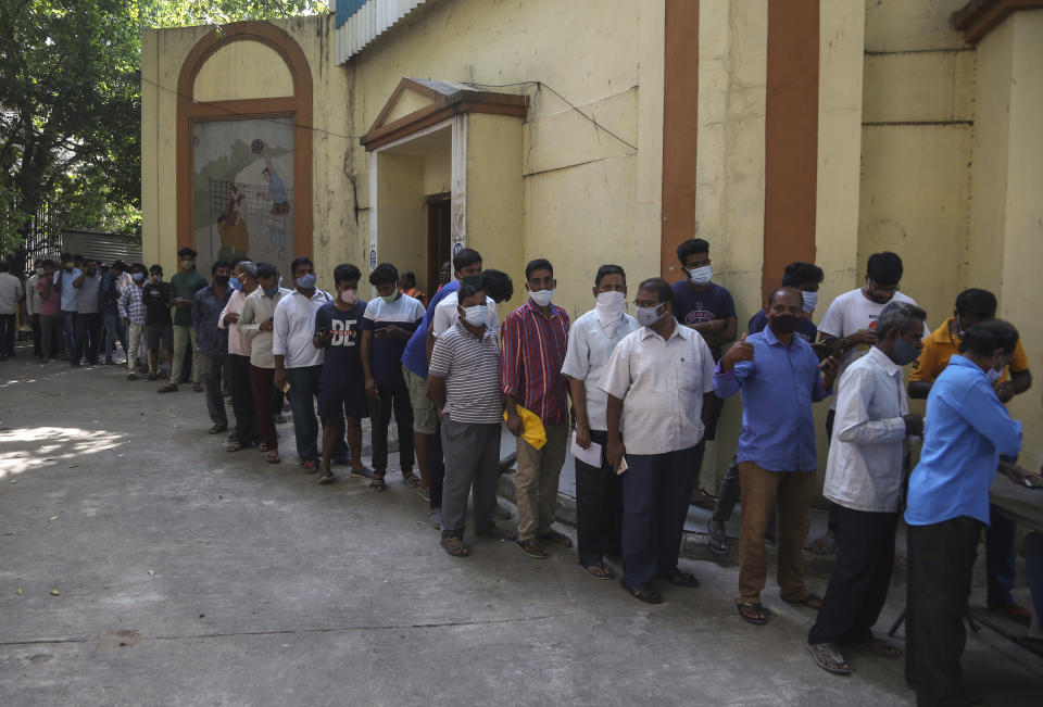 People wait to register their names to get inoculated agains the coronavirus in Hyderabad, India, Thursday, Oct. 21, 2021. India has administered 1 billion doses of COVID-19 vaccine, passing a milestone for the South Asian country where the delta variant fueled its first crushing surge this year. (AP Photo/Mahesh Kumar A.)