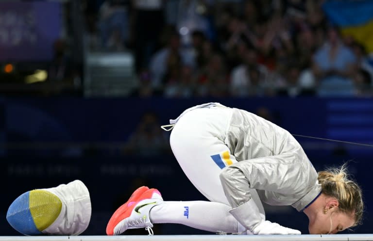 La esgrimista ucraniana Olga Kharlan besa el suelo para celebrar la medalla de bronce en sable individual en los Juegos Olimpicos de París, la primera para su país, en el Grand Palais de la capital francesa el 29 de julio del 2024 (Fabrice COFFRINI)