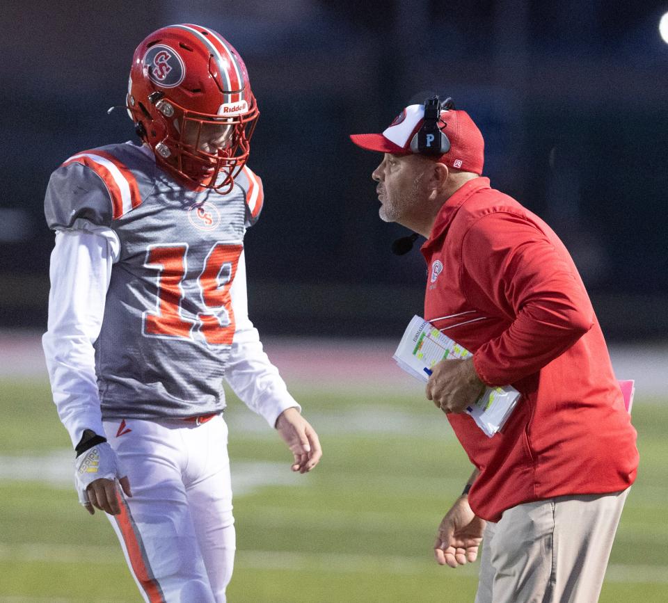 Canton South quarterback Matt Dennison talks with quarterback Poochie Snyder during Friday's game against Fairless.