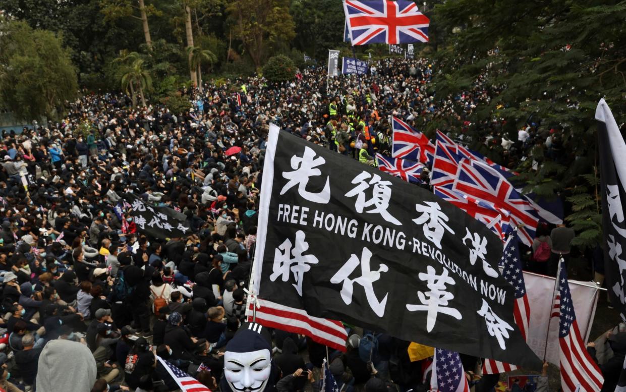 Hong Kong protesters wave British and US flags during a rally protesting against Beijing's new national security law earlier this year - Ng Han Guan/AP Photo