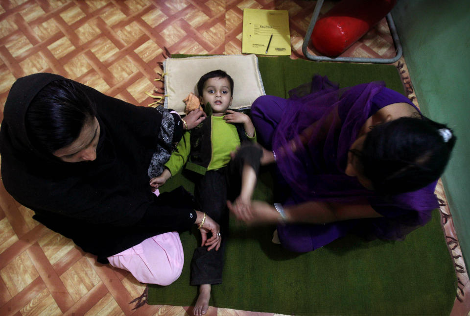 In this photo taken Tuesday, March 13, 2012, Firdous, 4, born mentally and physically disabled, a second generation victim of 1984 gas leak at the Union Carbide plant, goes through a physiotherapy session at a clinic, in Bhopal clinic in Bhopal, India. The survivors of the tragedy of 27 years ago, with their lingering illnesses, sick children and dead relatives, faded away from the world's memory, even as their suffering went on. Now, though, they have seized on a new chance to force their plight in front of the world, the London Olympics. (AP Photo/Rafiq Maqbool)
