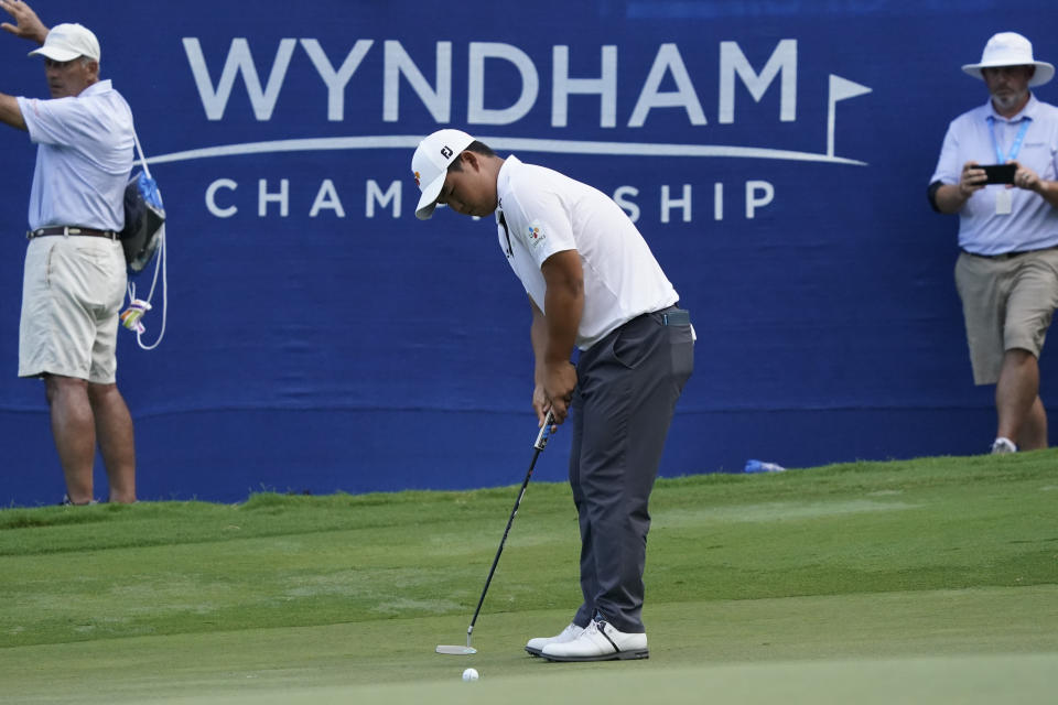 Joohyoung Kim, right, of South Korea, putts on the 18th hole during the final round of the Wyndham Championship golf tournament in Greensboro, N.C., Sunday, Aug. 7, 2022. (AP Photo/Chuck Burton)
