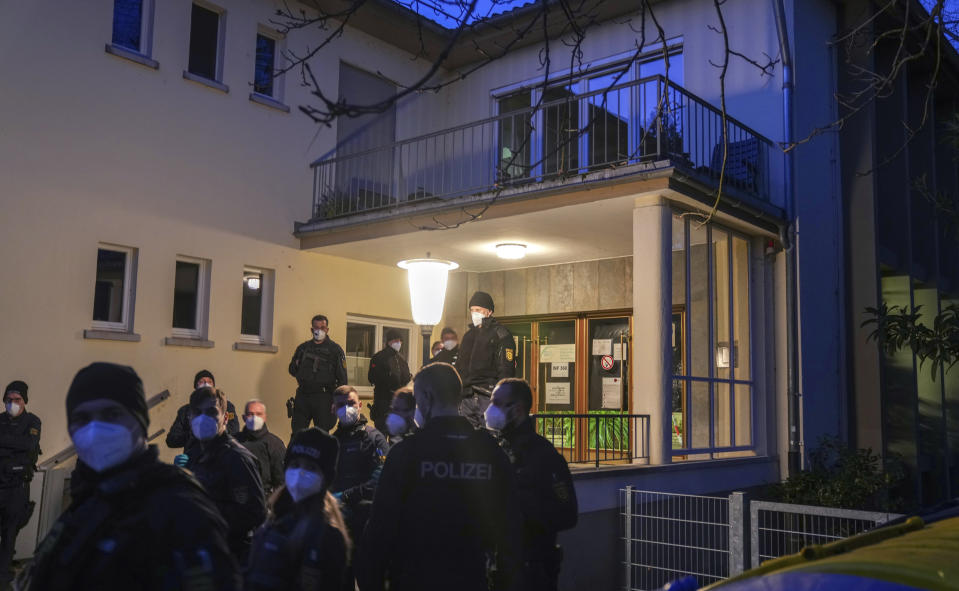 Police officers stay in front of the crime scene on the grounds of the Heidelberg University in Heidelberg, Germany, Monday, Jan. 24, 2022. German police say a lone gunman wounded several people at a lecture theatre in the southwest city of Heidelberg on Monday. Police said in a brief statement that the perpetrator was dead but didn't give details of how that happened. (AP Photo/Michael Probst)