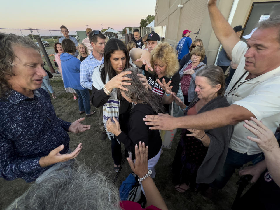 FILE - Amanda Grace of Ark of Grace Ministries and a group of people gather in prayer around a woman for the laying of hands during the ReAwaken America Tour at Cornerstone Church in Batavia, N.Y., Aug. 12, 2022. (AP Photo/Carolyn Kaster, File)