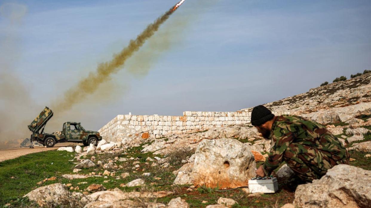 <div>A Syrian fighter affiliated with the Hayat Tahrir al-Sham (HTS) group operates the remote for a pickup-mounted rocket launcher firing at Syrian government forces' positions in the northwest of Aleppo province on January 1, 2024. (Photo by Omar HAJ KADOUR / AFP) (Photo by OMAR HAJ KADOUR/AFP via Getty Images)</div>