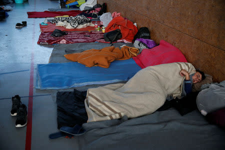 A Kurdish migrant from Irak rests inside a gymnasium in Grande-Synthe, France, January 9, 2019. Picture taken January 9, 2019. REUTERS/Pascal Rossignol