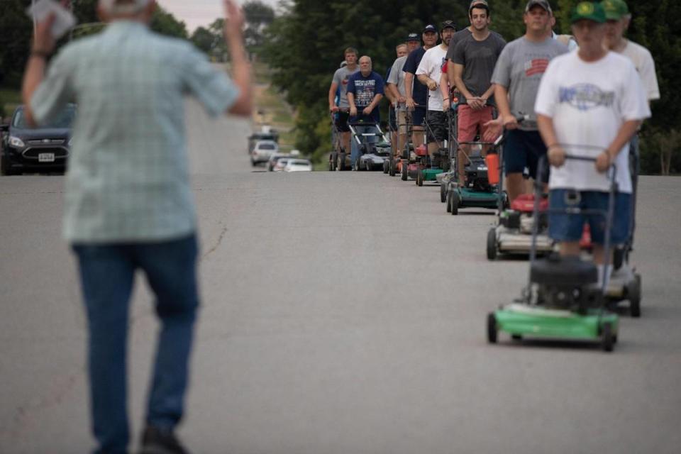 Glen Flanigan, left, Wilmore Lawnmower Brigade co-director, leads the group’s members in a practice session in Wilmore, Ky., on Thursday, June 30, 2022.
