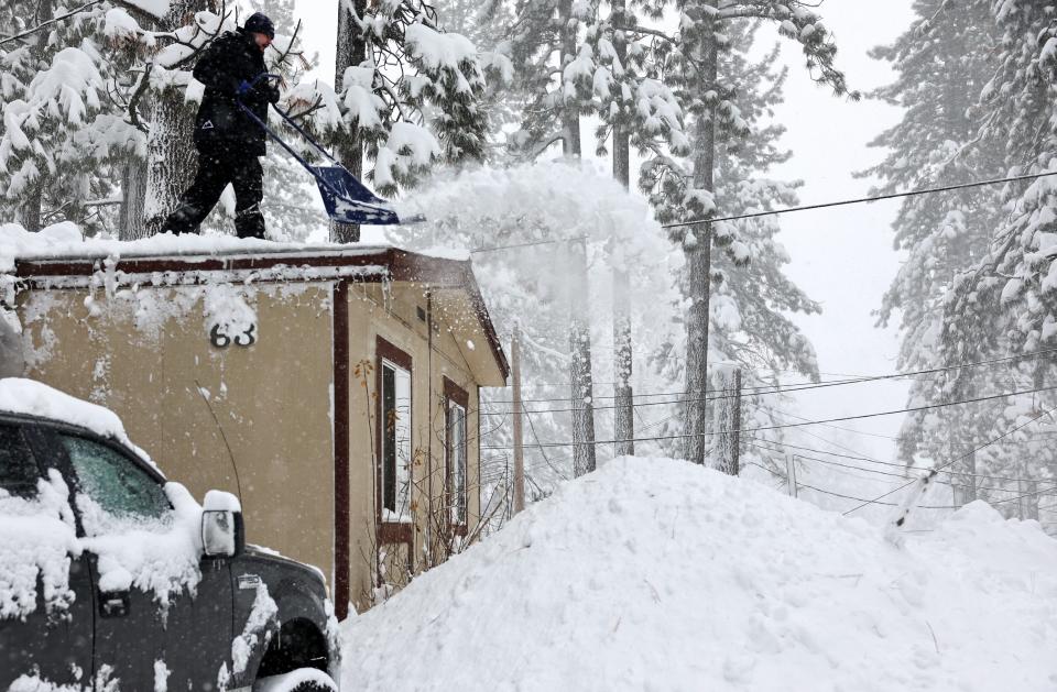 A resident of a mobile home community shovels snow from their rooftop during a powerful multiple day winter storm in the Sierra Nevada mountains on Saturday in Truckee, California. Mobile homes are at risk of roof collapse during heavy snowstorms.