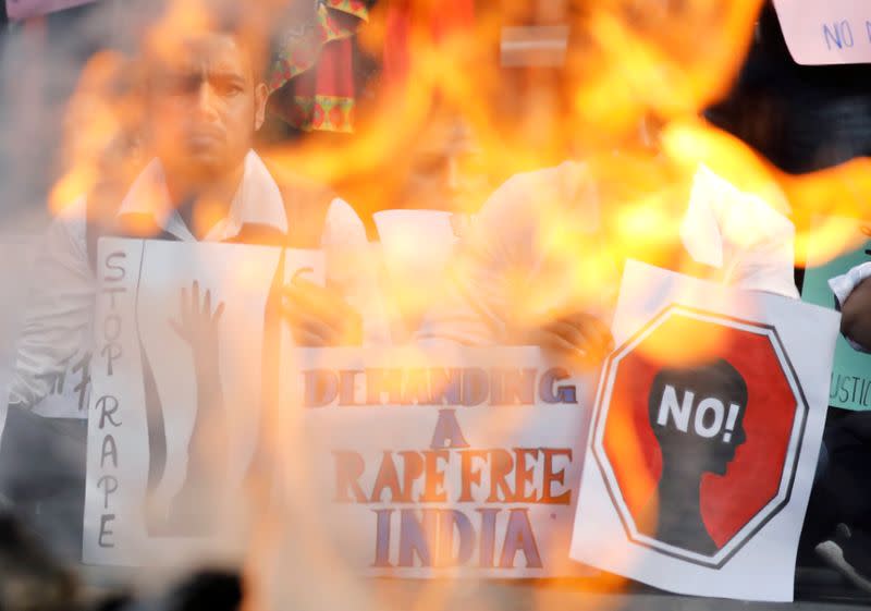People hold placards and shout slogans as they take part in a protest against the alleged rape and murder of a 27-year-old woman on the outskirts of Hyderabad, in New Delhi