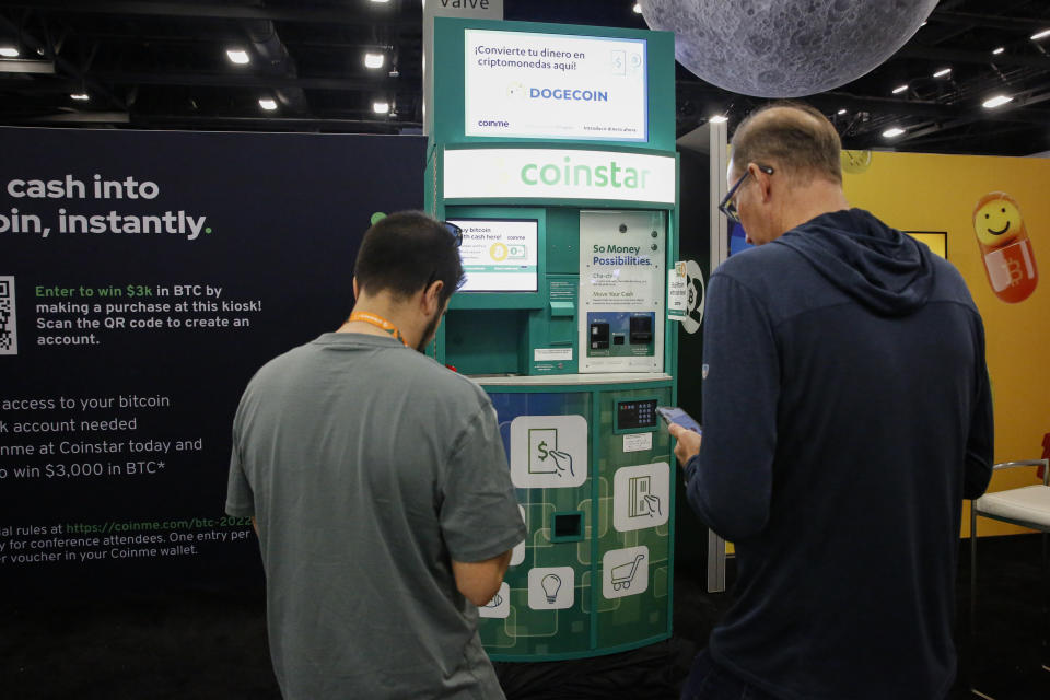 People buy bitcoin at a Coinstar ATM in the exhibition hall during the Bitcoin 2022 Conference on April 8, 2022, in Miami. (Photo by Marco Bello/Getty Images)