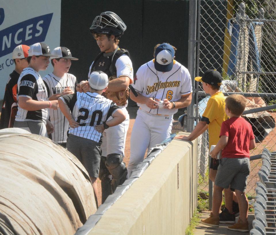 Norwich All-Star catcher Joey DeMucci and Matt Reyes (6) sign autographs before the Sea Unicorns game against Nashua on Sunday at Dodd Stadium.