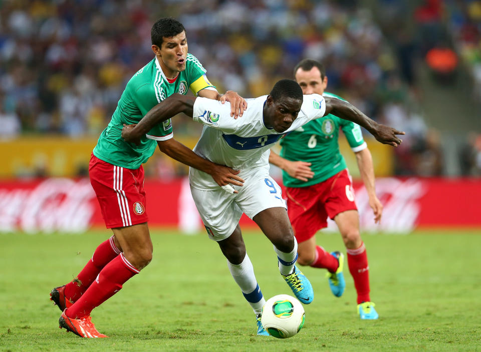 RIO DE JANEIRO, BRAZIL - JUNE 16: Mario Balotelli of Italy is challenged by Francisco Javier Rodriguez of Mexico during the FIFA Confederations Cup Brazil 2013 Group A match between Mexico and Italy at the Maracana Stadium on June 16, 2013 in Rio de Janeiro, Brazil. (Photo by Ronald Martinez/Getty Images)