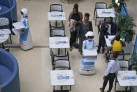 Robotic waiters serve customers at Robot Cafe in Nairobi, Kenya Thursday, Aug. 29, 2024. Robot Café, is first of a kind in Nairobi and East Africa, where three robots glide among human waiters serving food to mesmerized customers. (AP Photo/Brian Inganga)