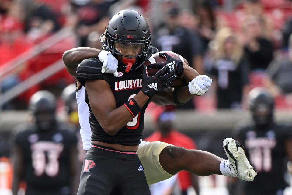 Oct 29, 2022; Louisville, Kentucky, USA;  Louisville Cardinals wide receiver Tyler Hudson (0) catches a pass under the pressure of the Wake Forest Demon Deacons during the first quarter at Cardinal Stadium. Mandatory Credit: Jamie Rhodes-USA TODAY Sports